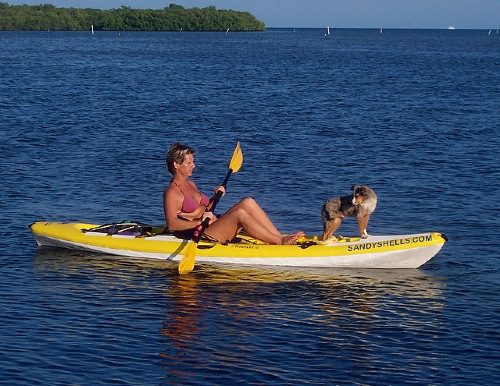 A woman kayaking with her dog