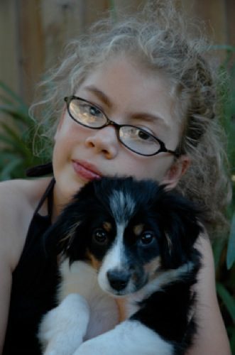 A black and white dog being held by a blonde woman